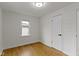 Clean bedroom with hardwood floors, white walls, and a window offering natural light at 2046 N Tibbs Ave, Indianapolis, IN 46222