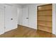 Bright bedroom with hardwood floors and a built-in, light-wood storage shelving unit at 2046 N Tibbs Ave, Indianapolis, IN 46222