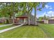 A quaint home displays a red porch and green lawn, framed by mature trees at 2046 N Tibbs Ave, Indianapolis, IN 46222