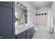 Bright bathroom featuring grey cabinets, vanity with mirror, and shower with bathtub at 24 Shannon Rd, Zionsville, IN 46077
