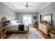 Bright bedroom showcasing hardwood floors, a ceiling fan, a window with tree views, and light gray walls at 24 Shannon Rd, Zionsville, IN 46077