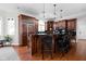 Open concept kitchen showcases dark wood cabinets, island seating, and recessed lighting at 24 Shannon Rd, Zionsville, IN 46077