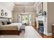 Spacious main bedroom with vaulted ceilings, chandelier, fireplace and seating area with backyard views at 24 Shannon Rd, Zionsville, IN 46077