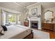 Bright main bedroom featuring a fireplace, chandelier and a backyard view at 24 Shannon Rd, Zionsville, IN 46077