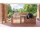 Outdoor kitchen area featuring stainless steel appliances and granite countertops, set against a brick backdrop at 24 Shannon Rd, Zionsville, IN 46077