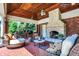 Inviting outdoor living space with brick patio, stone fireplace, comfortable seating and complete outdoor kitchen at 24 Shannon Rd, Zionsville, IN 46077