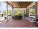 Covered brick patio with a long dining table, ideal for outdoor entertaining and enjoying the surrounding landscape at 24 Shannon Rd, Zionsville, IN 46077