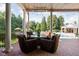 Spacious covered patio with comfortable seating, overlooking a lush yard and swimming pool with a poolhouse at 24 Shannon Rd, Zionsville, IN 46077