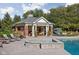 Pool house with a stone fireplace, comfortable seating and ample lounging space, surrounded by lush landscaping at 24 Shannon Rd, Zionsville, IN 46077