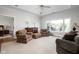 Bright sitting room boasts a large window with tree views, elegant furnishings, neutral colors, and a ceiling fan at 24 Shannon Rd, Zionsville, IN 46077