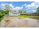 View of the home's back exterior, featuring a lawn and a concrete patio area, enhanced by a wooden fence at 2726 Apache Dr, Anderson, IN 46012