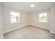Well-lit bedroom with light, wood-look flooring and two exterior-facing windows at 2726 Apache Dr, Anderson, IN 46012