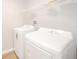Bright laundry area featuring new, white, front-loading washer and dryer with wire shelving above at 2726 Apache Dr, Anderson, IN 46012