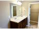 Bathroom featuring double sink vanity with a large mirror, and an open doorway to a walk-in closet at 276 Rocky Rd, Greenfield, IN 46140