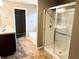 Bathroom featuring double sinks, a soaking tub, walk-in shower with glass doors, and tan flooring at 276 Rocky Rd, Greenfield, IN 46140