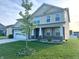Beautiful two-story home with well-manicured lawn, a young tree and a convenient two car garage at 276 Rocky Rd, Greenfield, IN 46140