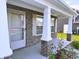 Cozy covered front porch with brick accents, white columns and a decorative front door at 276 Rocky Rd, Greenfield, IN 46140