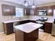 Modern kitchen featuring dark wood cabinets, stainless steel appliances, a center island and unique pendant lights at 276 Rocky Rd, Greenfield, IN 46140