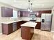 Modern kitchen featuring dark cabinets, stainless steel appliances, a stylish island and wood-look flooring at 276 Rocky Rd, Greenfield, IN 46140