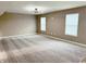 Spacious living room featuring neutral carpet, light walls, multiple windows, and a modern chandelier at 276 Rocky Rd, Greenfield, IN 46140