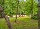 Lush backyard leading to a river, accented by bright red Adirondack chairs at 2781 E Vandalia Rd, Flat Rock, IN 47234