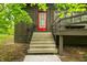 Inviting home entrance with charming steps, a quaint porch, and a vibrant red front door at 2781 E Vandalia Rd, Flat Rock, IN 47234