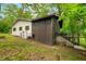 Side of house with AC unit, leading up to a deck and stairs, surrounded by lush trees at 2781 E Vandalia Rd, Flat Rock, IN 47234