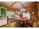 Charming kitchen with wood-paneled walls, dining table with seating, and retro appliances at 2781 E Vandalia Rd, Flat Rock, IN 47234