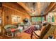 Cozy living room featuring wood paneling, exposed beams, comfortable seating, and natural light at 2781 E Vandalia Rd, Flat Rock, IN 47234
