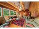 Cozy living room with wood paneling, cathedral ceilings, ceiling fan, exposed beams, and ample seating at 2781 E Vandalia Rd, Flat Rock, IN 47234
