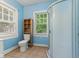 A bright bathroom features a tiled floor, a shower, and natural light from two windows at 3134 N College Ave, Indianapolis, IN 46205