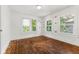 Sunlit bedroom with hardwood floors and white trim around the three windows at 3134 N College Ave, Indianapolis, IN 46205