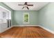 Green bedroom with ceiling fan and natural light at 3134 N College Ave, Indianapolis, IN 46205
