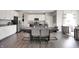 Open dining area with dark wood table and seating for six, adjacent to modern kitchen and living room at 3200 Glasgow Pl, Danville, IN 46122