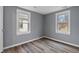 Cozy bedroom with two windows, grey walls, and modern wood-look flooring at 3305 N Arlington Ave, Indianapolis, IN 46218