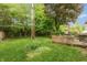 Lush backyard featuring a wooden deck, mature trees, and a grassy area at 3514 Summerfield Dr, Indianapolis, IN 46214