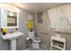 Bathroom with pedestal sink, toilet, window with natural light, and yellow color scheme at 3514 Summerfield Dr, Indianapolis, IN 46214