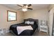 Bright bedroom with a window, dark color scheme, ceiling fan, and nightstand at 3514 Summerfield Dr, Indianapolis, IN 46214