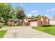 Traditional home exterior boasts a two-car garage, brick accents, and a spacious driveway, surrounded by lush trees at 3514 Summerfield Dr, Indianapolis, IN 46214
