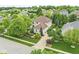 An aerial view showcases a light brick home with beautiful landscaping, mature trees, and a well-kept lawn at 3655 Copperleaf Blvd, Greenwood, IN 46143
