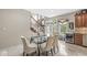 Dining area with tile floors, designer table and chairs, and view into the kitchen at 3655 Copperleaf Blvd, Greenwood, IN 46143