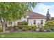 Beautiful brick home featuring lush landscaping, colorful flowers, and mature trees creating a welcoming entrance at 3655 Copperleaf Blvd, Greenwood, IN 46143