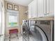 Bright laundry room featuring stainless steel washer and dryer with a window and tile flooring at 3655 Copperleaf Blvd, Greenwood, IN 46143