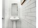 Stylish powder room with subway tile walls, a pedestal sink, and a modern mirror at 3671 Pinnacle Dr, Bargersville, IN 46106