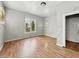 Empty bedroom with hardwood floors, a large window, and a door to another room at 401 Harlan St, Indianapolis, IN 46201