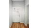 View of the entryway with a white door, gray walls, and wood flooring at 401 Harlan St, Indianapolis, IN 46201