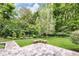 Serene backyard with a patio, well-manicured lawn, and mature trees at 445 W 63Rd St, Indianapolis, IN 46260