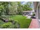 Expansive backyard with lush landscaping, a screened in porch, and charming details at 445 W 63Rd St, Indianapolis, IN 46260