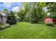 Large backyard featuring a lush lawn, storage shed, and mature trees at 445 W 63Rd St, Indianapolis, IN 46260