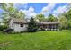 Scenic backyard view highlighting a screened porch, lush lawn, and mature landscaping at 445 W 63Rd St, Indianapolis, IN 46260